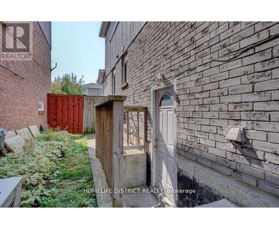 A realtor brokerage sign is on a brick wall.