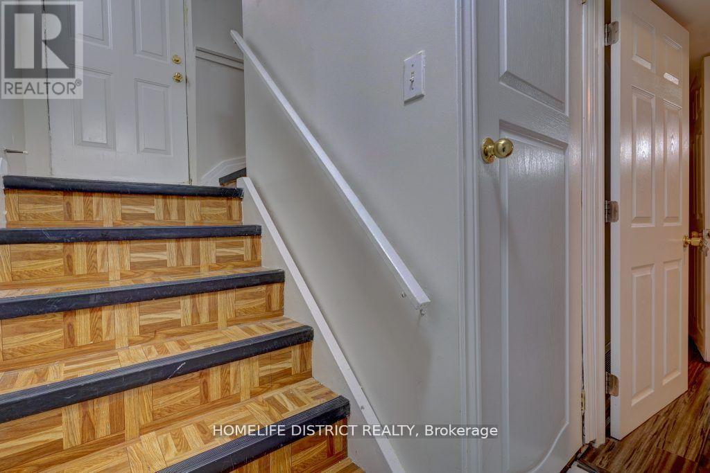A staircase with wooden steps and a white wall.