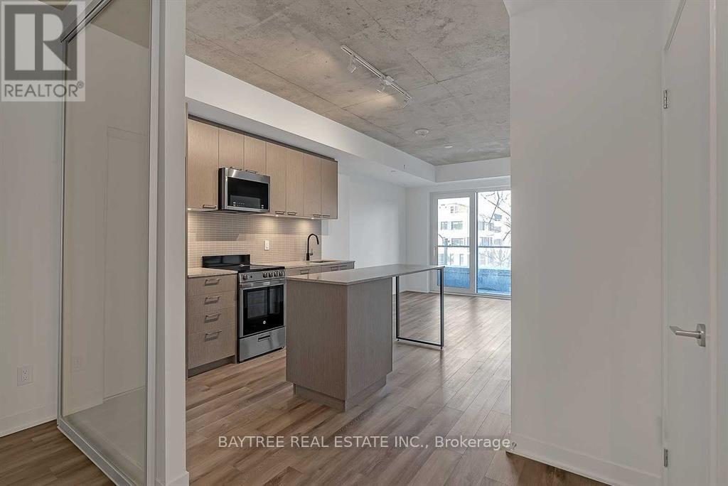 A modern kitchen with a microwave above the oven and a countertop with a sink.
