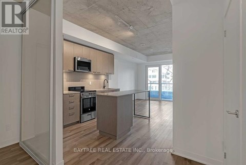 A modern kitchen with a microwave above the oven and a countertop with a sink.