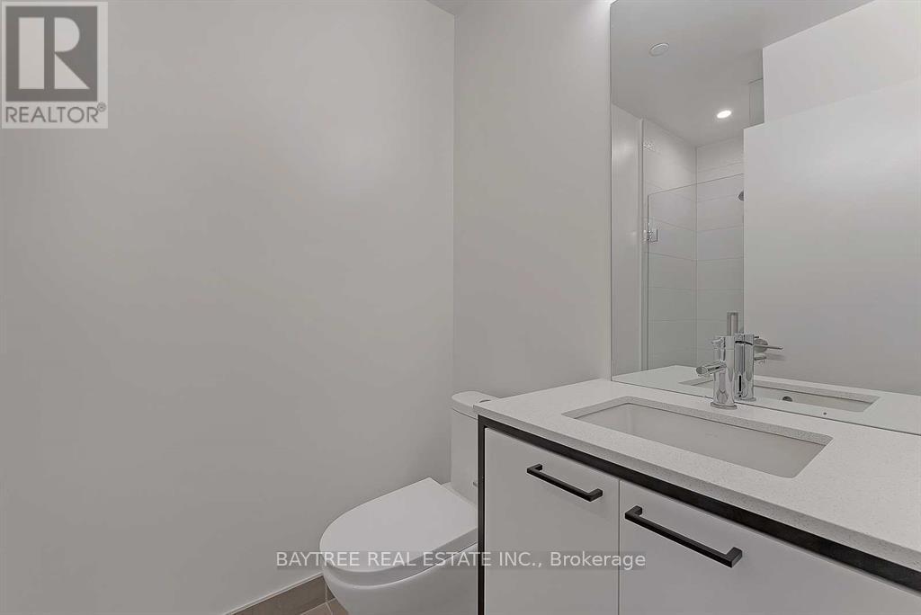 A white bathroom with a sink, toilet and mirror.