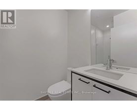 A white bathroom with a sink, toilet and mirror.