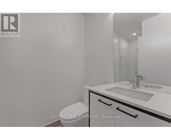A white bathroom with a sink, toilet and mirror.
