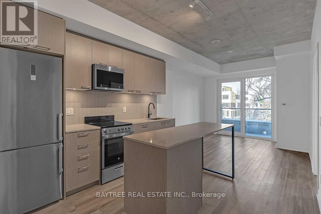 A modern kitchen with a refrigerator, oven, and microwave.
