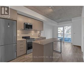 A modern kitchen with a refrigerator, oven, and microwave.