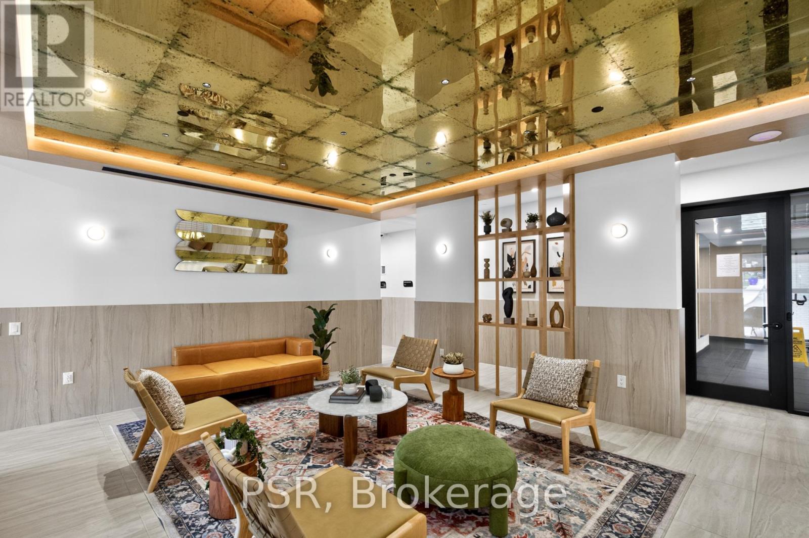 A well-lit, modern living room with a variety of seating options and a large rug.