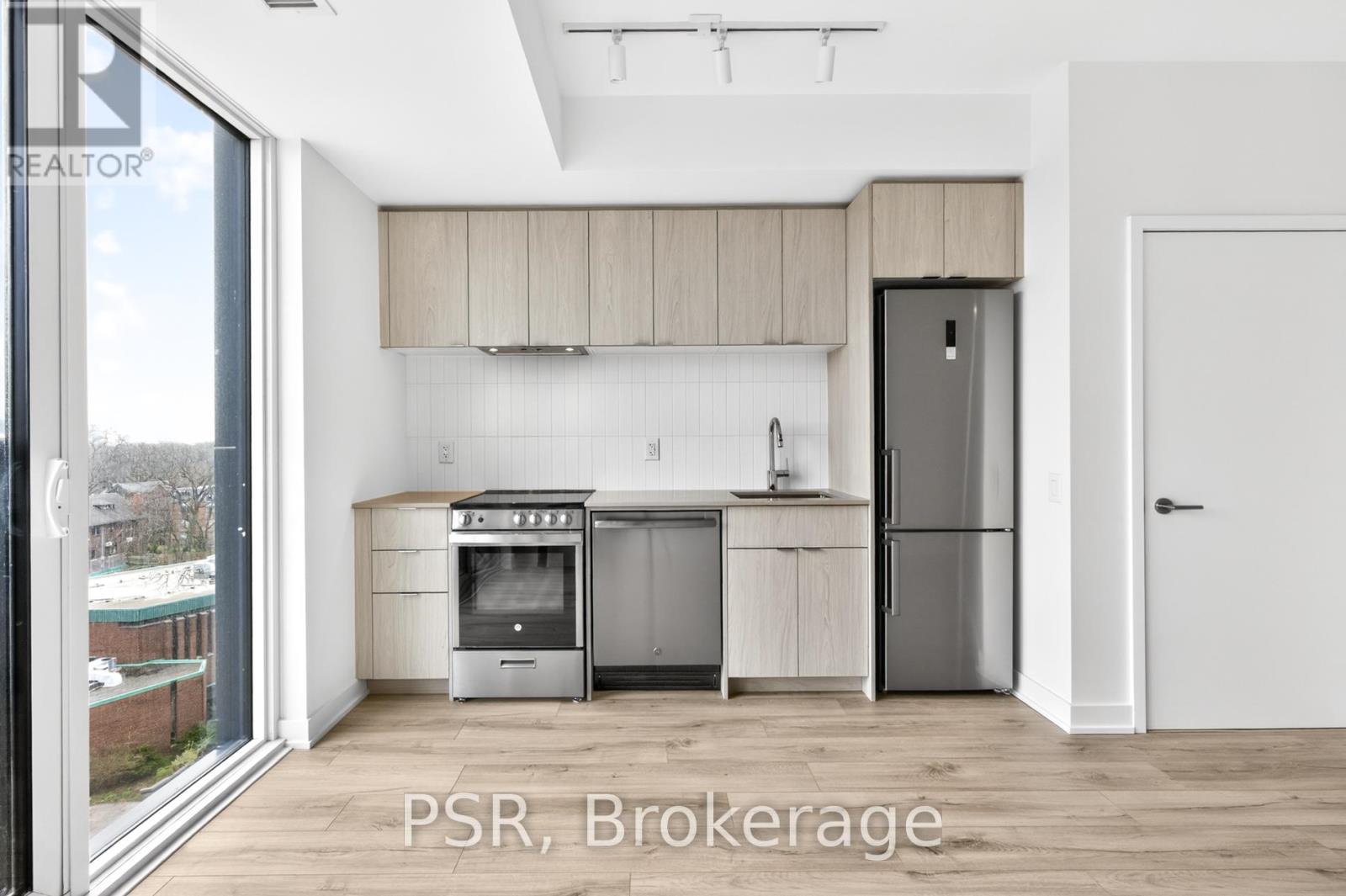 A modern kitchen with wooden cabinets and stainless steel appliances.