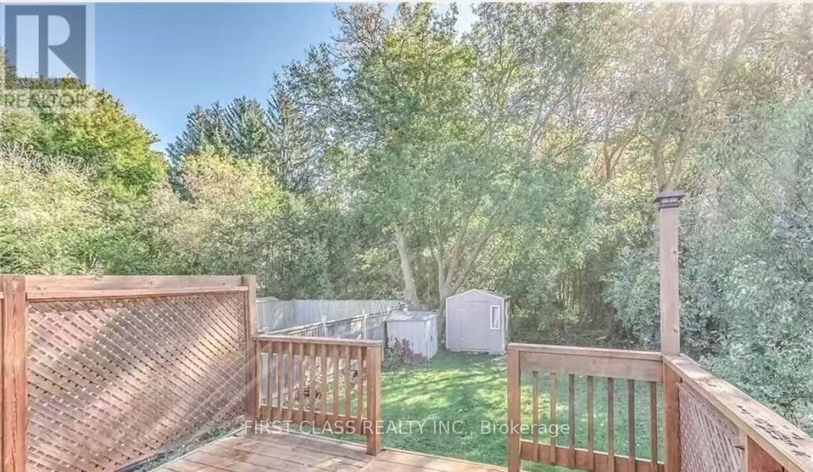 A wooden deck with a lattice fence and a view of a backyard with a shed.