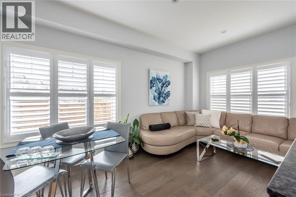 A well-lit living room with a glass dining table and chairs, a sofa, and a coffee table.