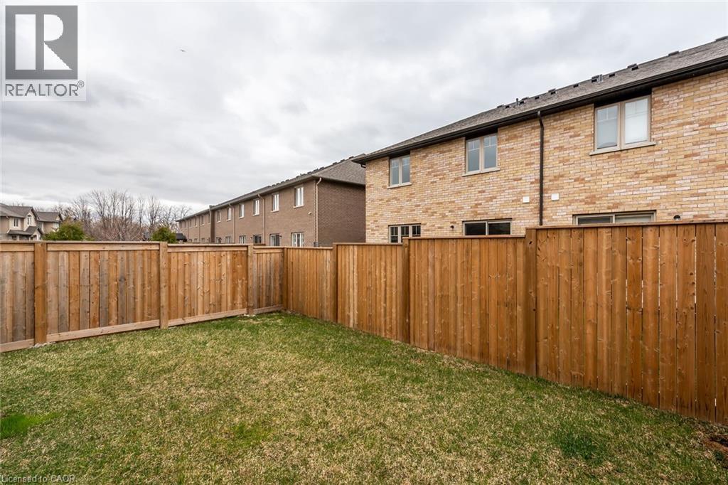 A backyard with a wooden fence and grass.