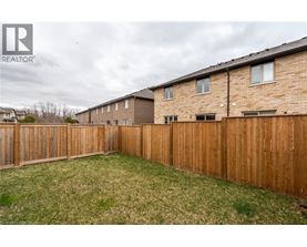 A backyard with a wooden fence and grass.