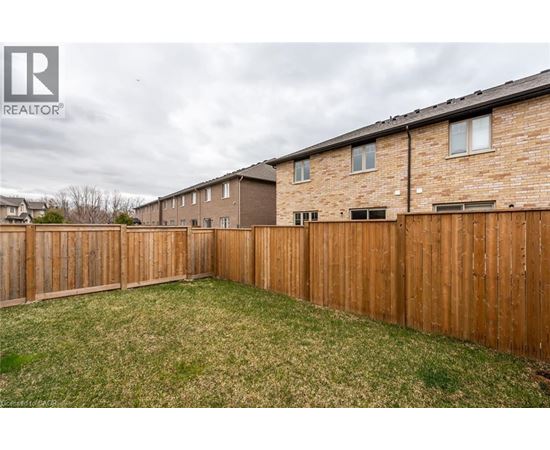A backyard with a wooden fence and grass.
