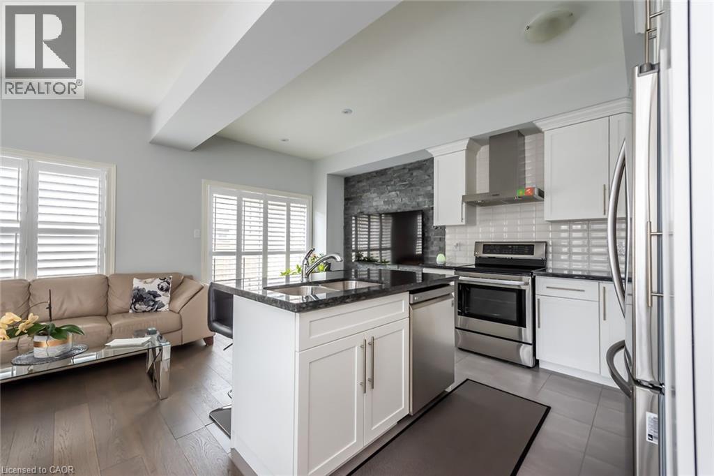 A modern kitchen with white cabinets and a black countertop.