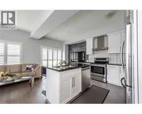 A modern kitchen with white cabinets and a black countertop.