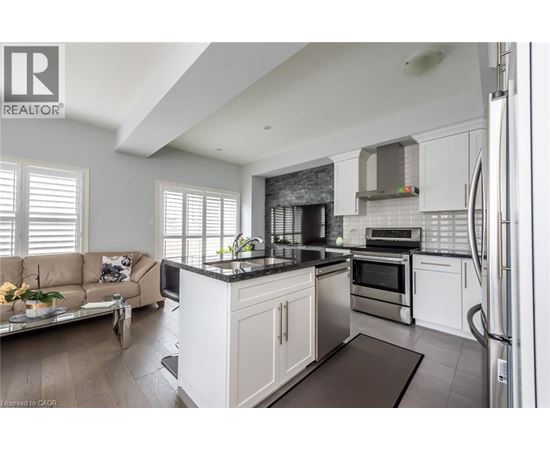 A modern kitchen with white cabinets and a black countertop.