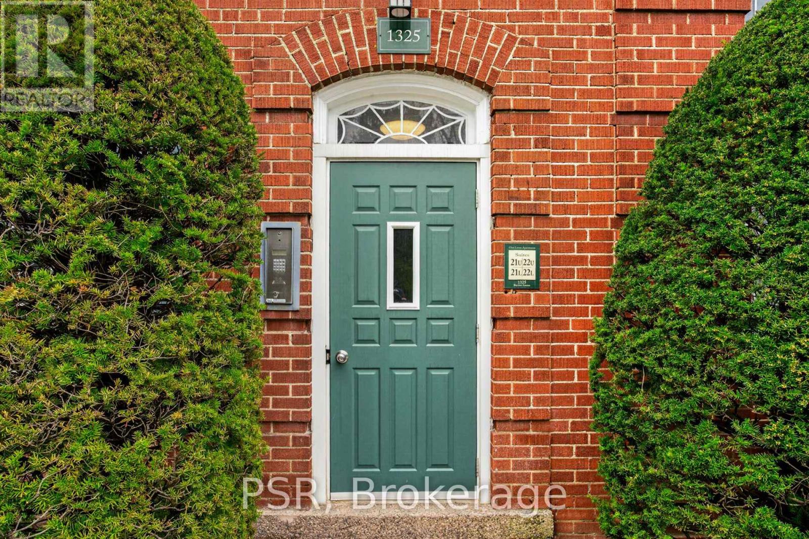 A green door is set in a brick wall.