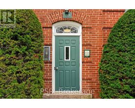 A green door is set in a brick wall.