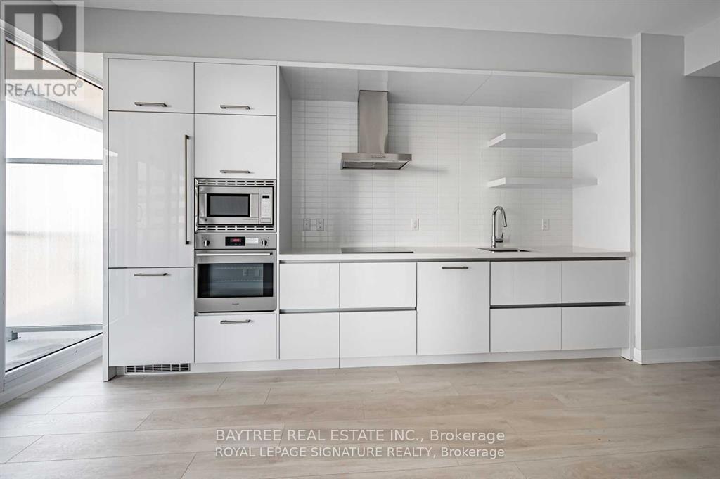 A modern kitchen with white cabinets and appliances.