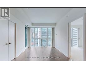 A spacious room with a view of a cityscape through the windows.