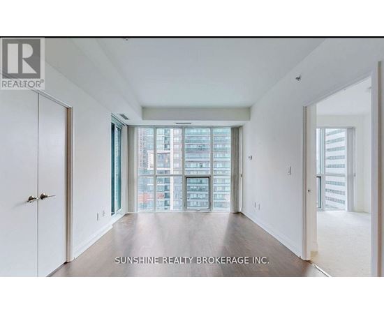 A spacious room with a view of a cityscape through the windows.