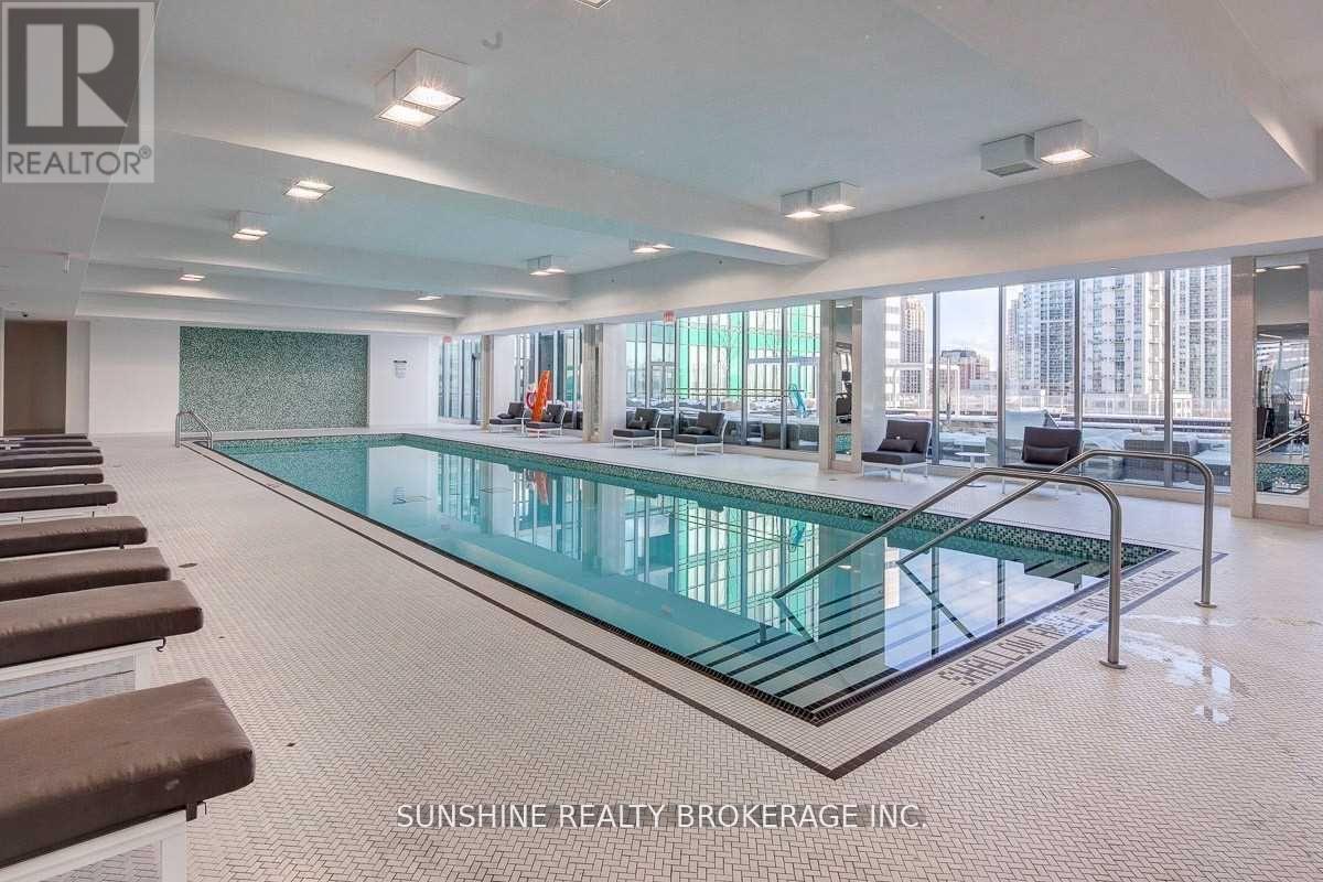 A large indoor swimming pool with a glass bottom and a tiled floor.