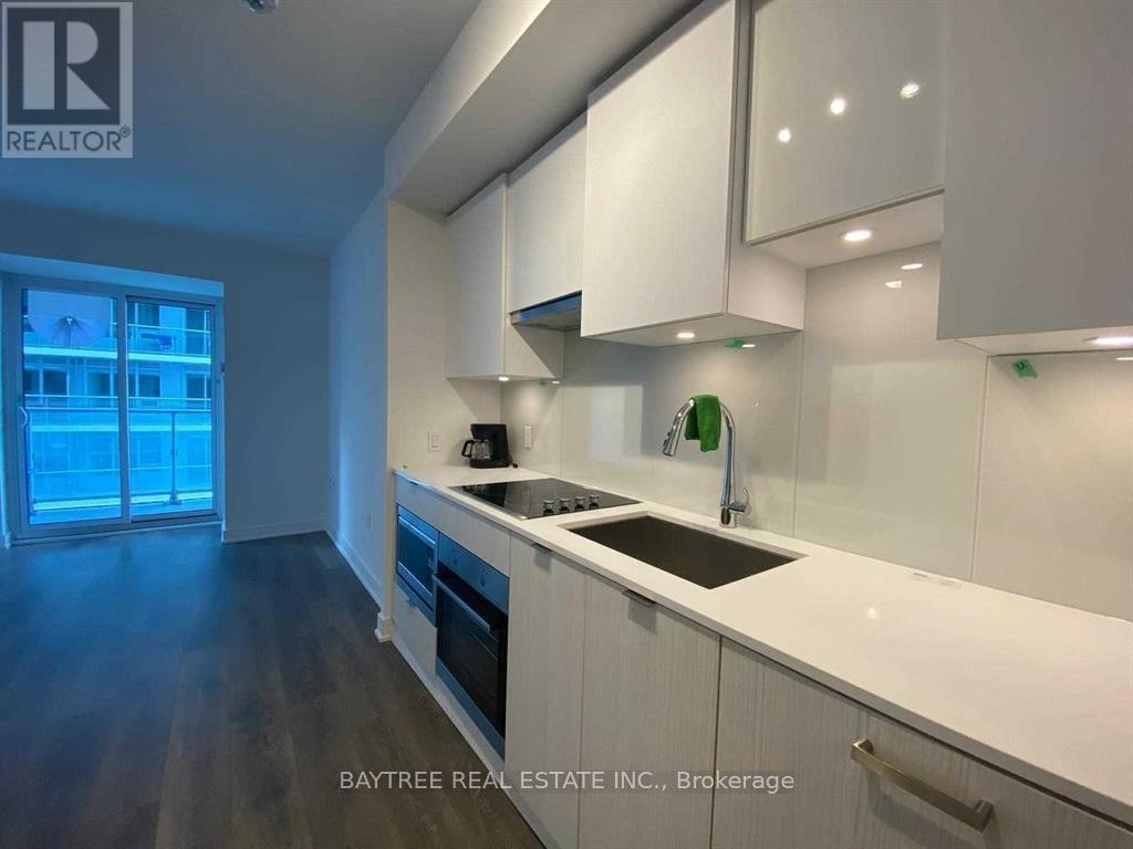 A modern kitchen with white cabinets and a dark floor.