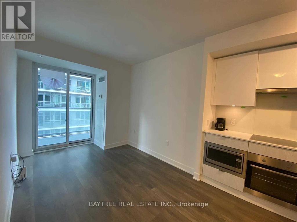 A spacious living room with a kitchenette and a view of the city.