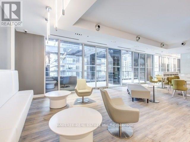 A modern living room with white furniture and a view of the city.