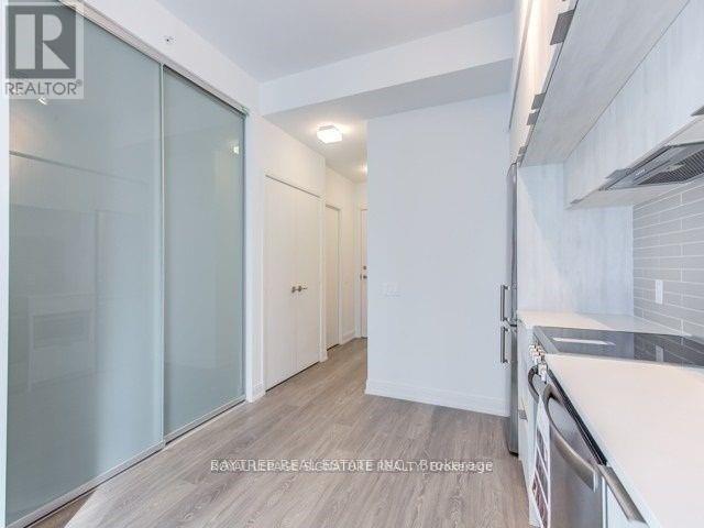 A modern kitchen with a glass door cabinet and a white countertop.