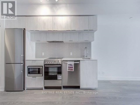 A kitchen with a refrigerator, oven, and microwave is for sale.