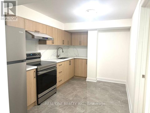 A kitchen with a refrigerator, oven, and sink.