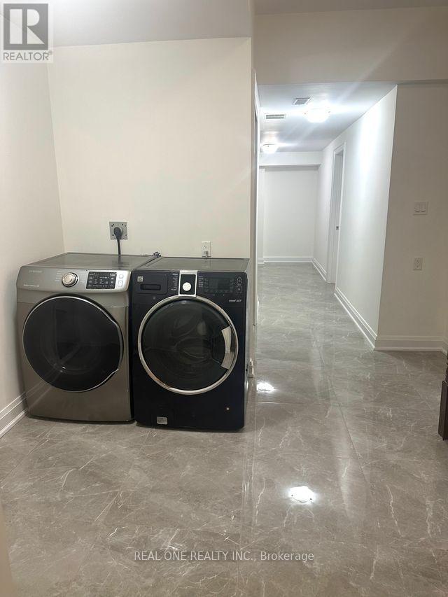 A pair of front load washing machines in a laundry room.