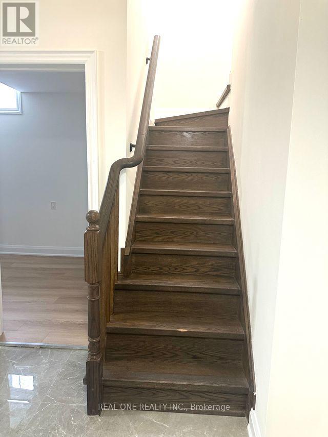 A wooden staircase with a white wall on the side.
