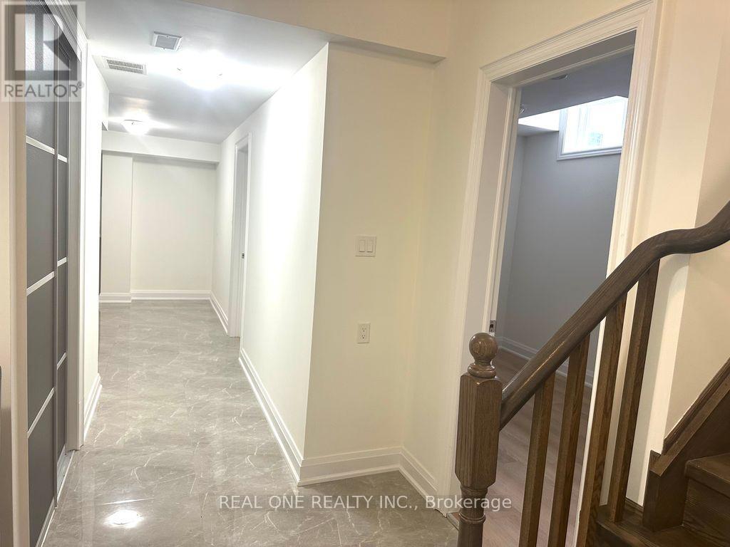 A hallway with a wooden staircase and white walls.