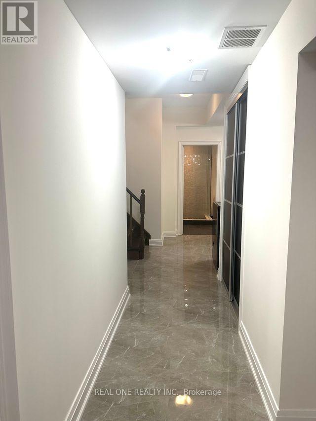 A hallway with marble flooring and white walls.