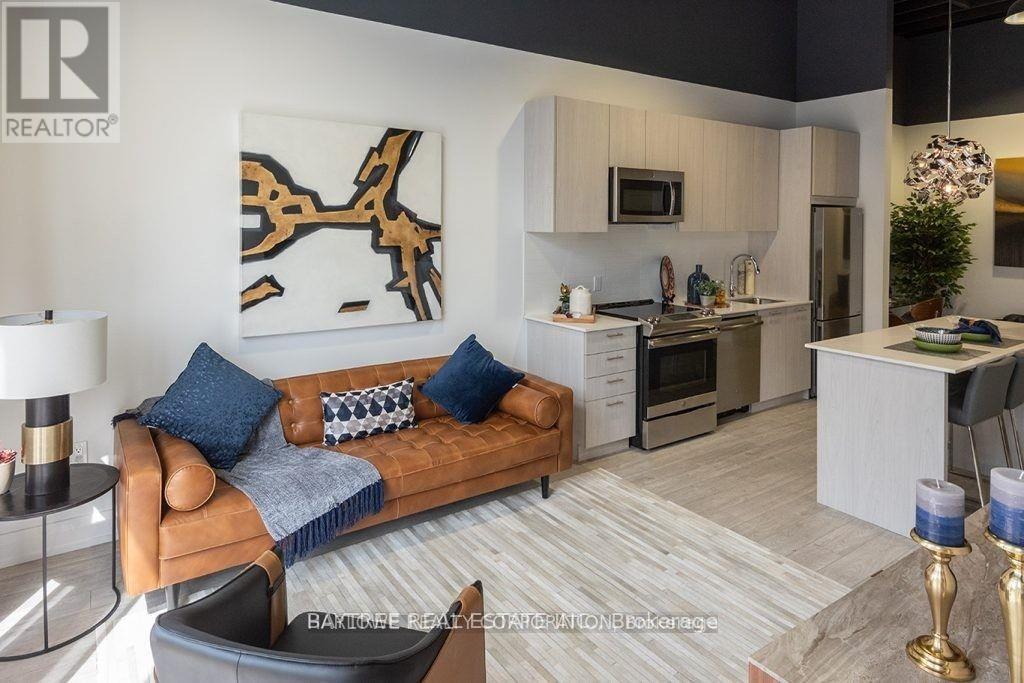A living room with a brown couch and a painting on the wall.