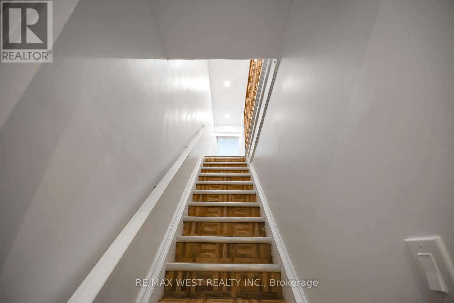 A staircase with wooden steps and white walls.