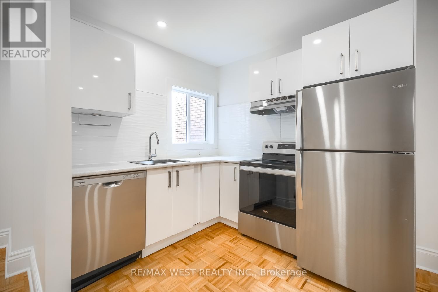 A kitchen with stainless steel appliances and white cabinets.