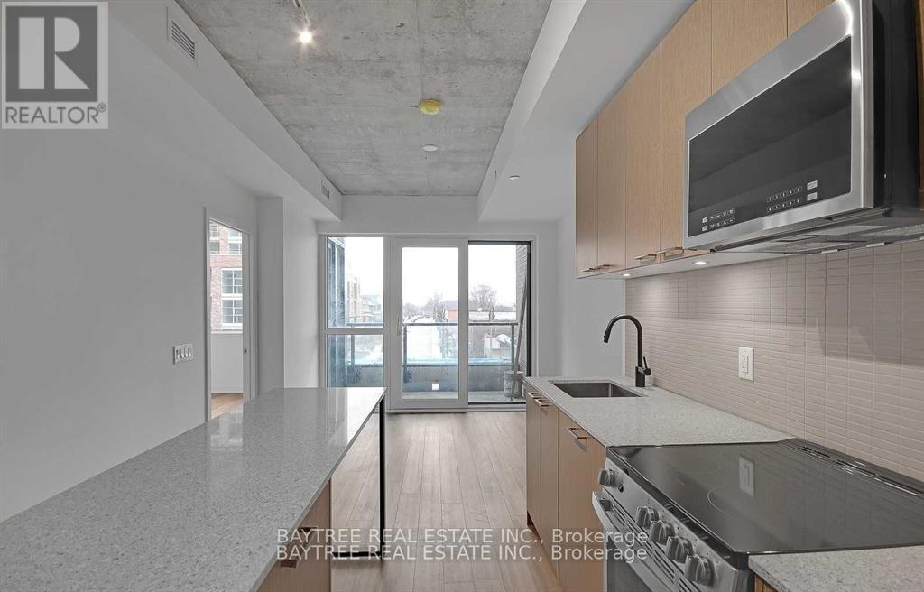 A modern kitchen with a large island and stainless steel appliances.