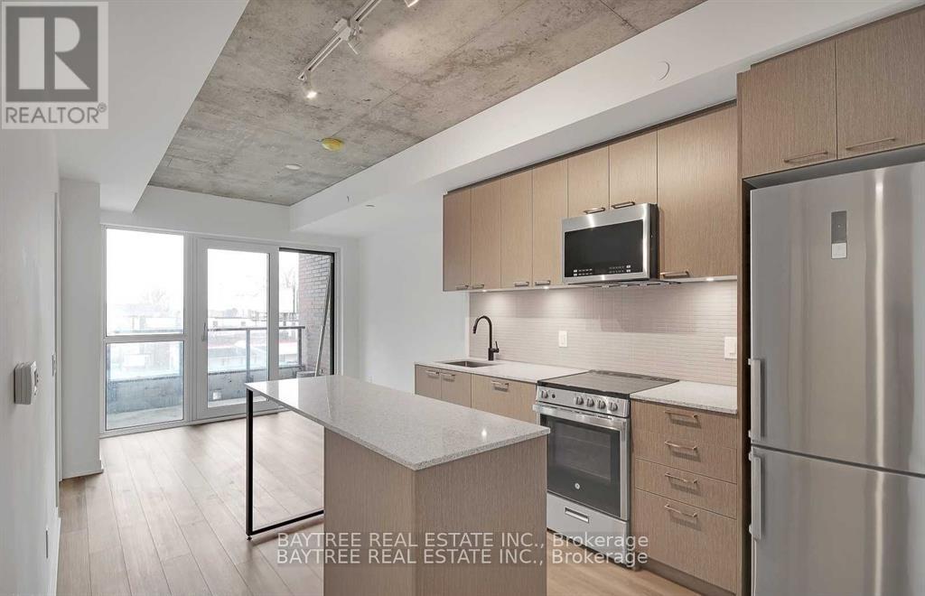 A modern kitchen with wooden cabinets and stainless steel appliances.