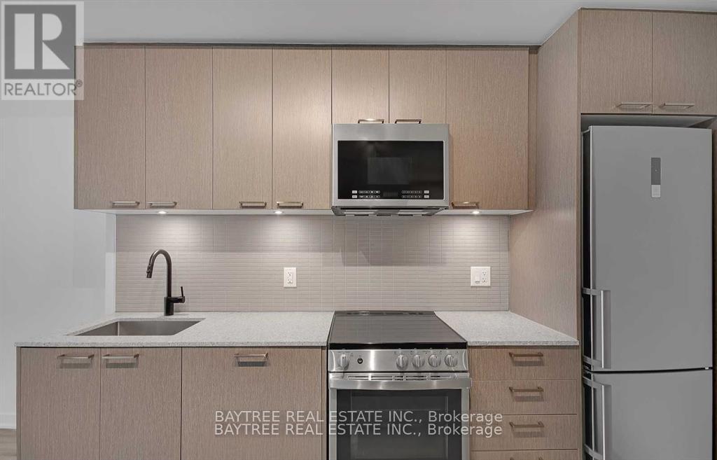 A kitchen with a sink, stove, and refrigerator.