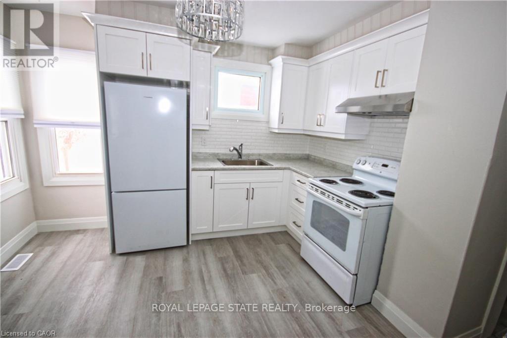 A kitchen with white appliances and cabinets.