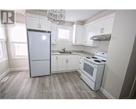 A kitchen with white appliances and cabinets.
