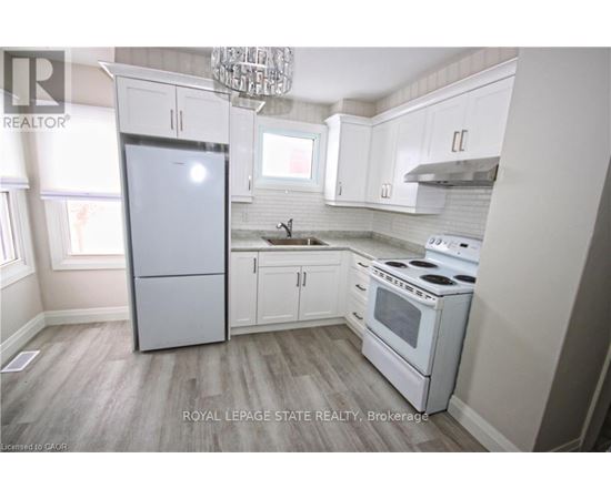 A kitchen with white appliances and cabinets.