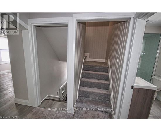 A stairway leads to a second floor bedroom.