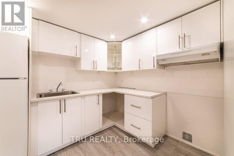 A white kitchen with a sink and cabinets.