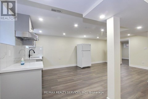 A kitchen area with a sink, a refrigerator, and a countertop.