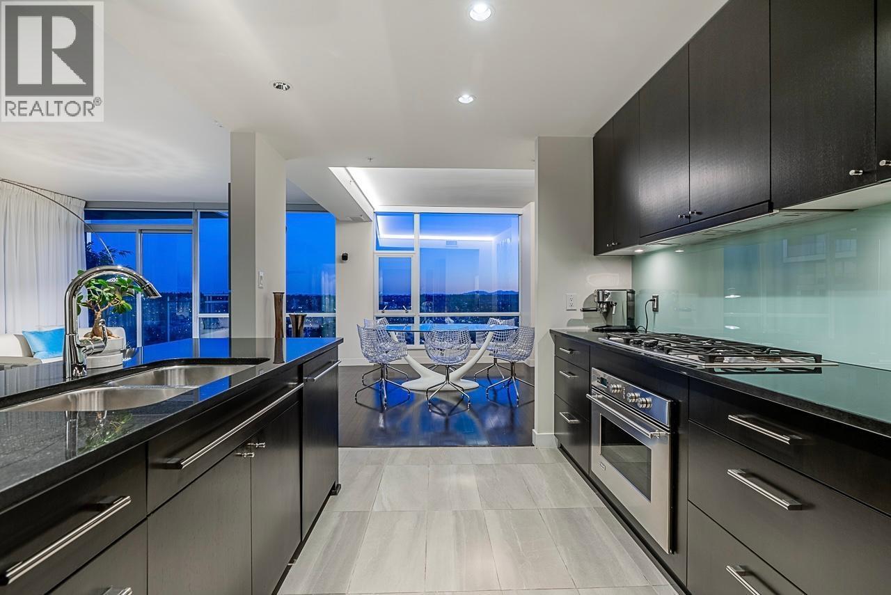 A modern kitchen with black cabinets and stainless steel appliances.