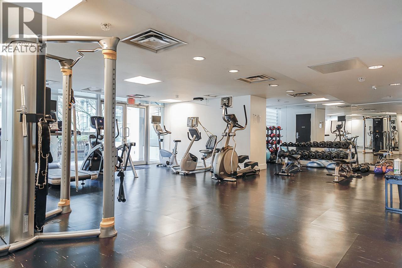 A gym with a variety of equipment including weights, cardio machines, and a squat rack.