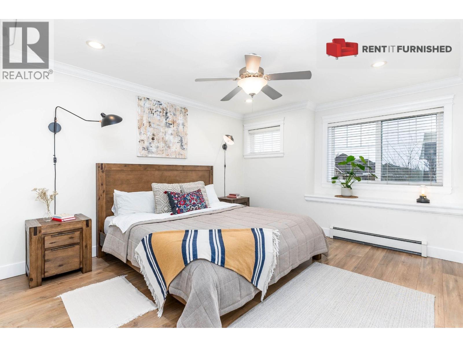 A bedroom with a bed, nightstand, and window.
